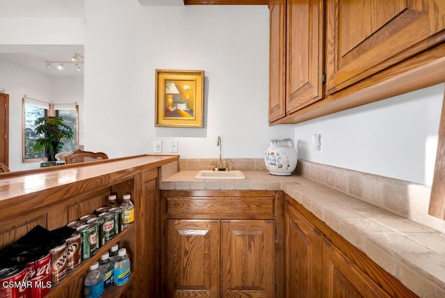 bar with tile countertops and sink