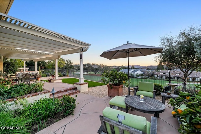 patio terrace at dusk featuring a pergola