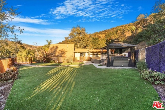 view of yard with a gazebo, a hot tub, a patio, a mountain view, and an outdoor living space