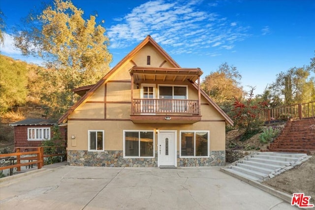 rear view of property featuring a balcony