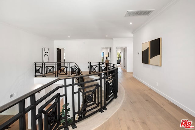 hallway featuring light hardwood / wood-style flooring and crown molding