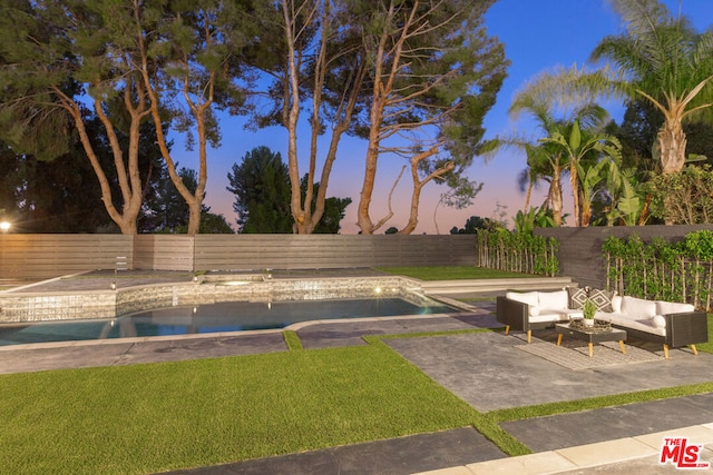 pool at dusk featuring an outdoor living space and a patio