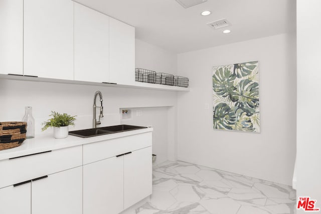 clothes washing area with cabinets, sink, and hookup for a washing machine