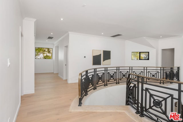 hall with crown molding and light wood-type flooring