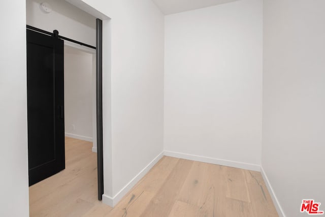 interior space with light hardwood / wood-style floors, a closet, and a barn door