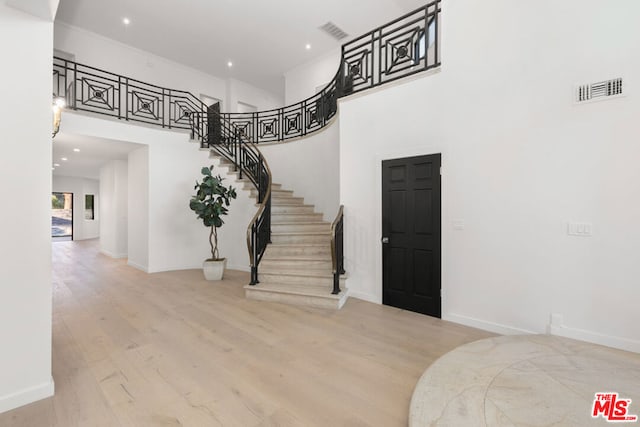 stairway featuring hardwood / wood-style flooring and a high ceiling