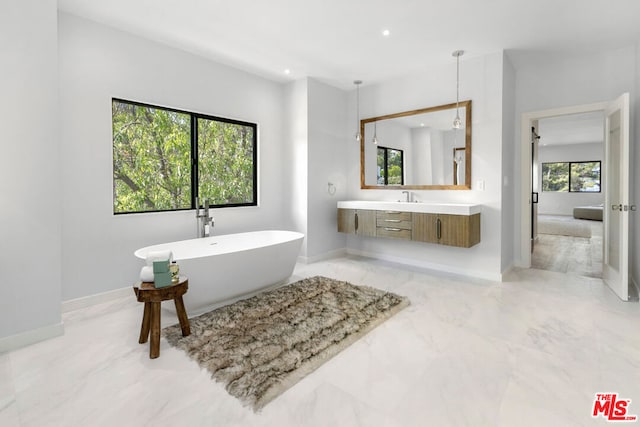 bathroom with a tub to relax in and vanity