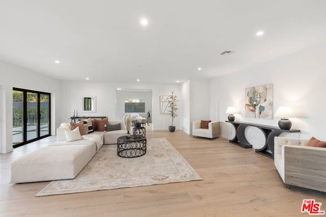 living room featuring french doors and light hardwood / wood-style flooring