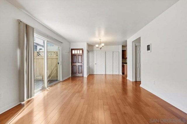 unfurnished room with hardwood / wood-style floors and a chandelier