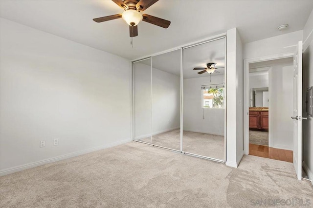 unfurnished bedroom with ceiling fan, light colored carpet, and a closet