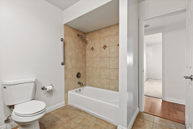 bathroom with toilet and tiled shower / bath combo