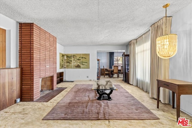 carpeted living room featuring a textured ceiling and a fireplace