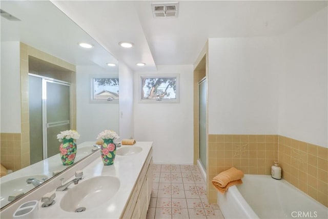 bathroom with visible vents, a sink, a shower stall, and a bath