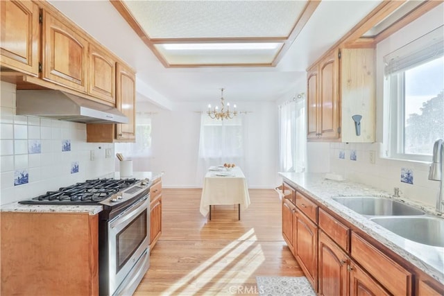 kitchen with sink, backsplash, light wood-type flooring, and stainless steel range with gas stovetop