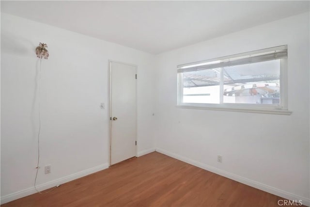 unfurnished room featuring light wood-style floors and baseboards