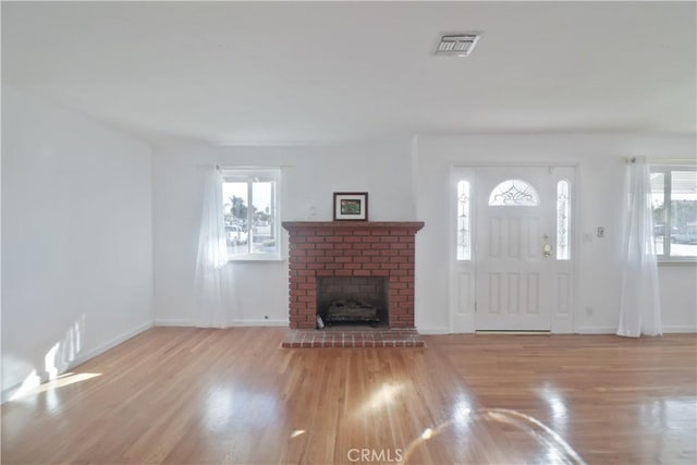 foyer featuring a healthy amount of sunlight, visible vents, and wood finished floors