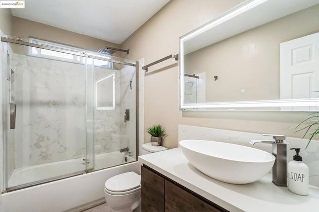 full bathroom with vanity, enclosed tub / shower combo, and toilet