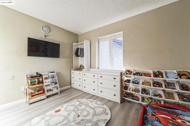 game room featuring hardwood / wood-style flooring and a textured ceiling