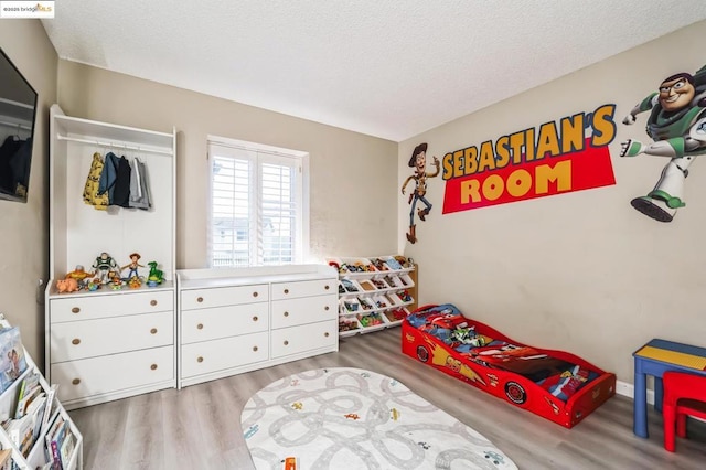 bedroom with wood-type flooring and a textured ceiling