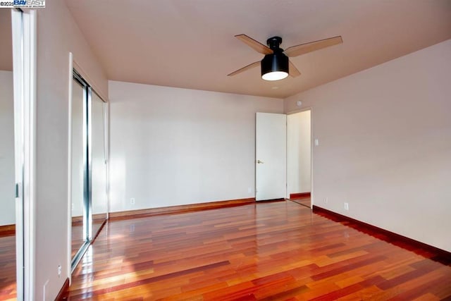 unfurnished bedroom featuring wood-type flooring, a closet, and ceiling fan