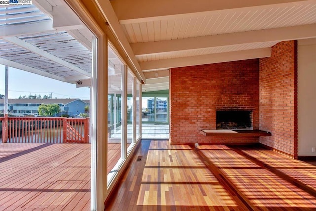 wooden terrace featuring a brick fireplace