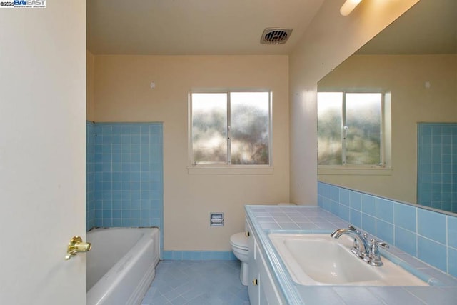 bathroom with vanity, toilet, and tile patterned flooring