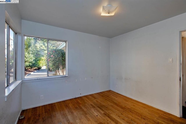 unfurnished room with wood-type flooring