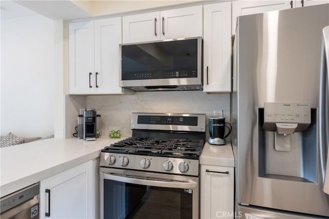 kitchen featuring backsplash, white cabinetry, and appliances with stainless steel finishes