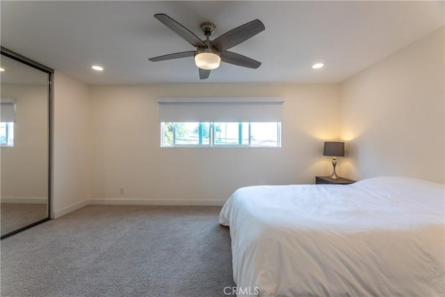 bedroom featuring ceiling fan, multiple windows, and carpet flooring