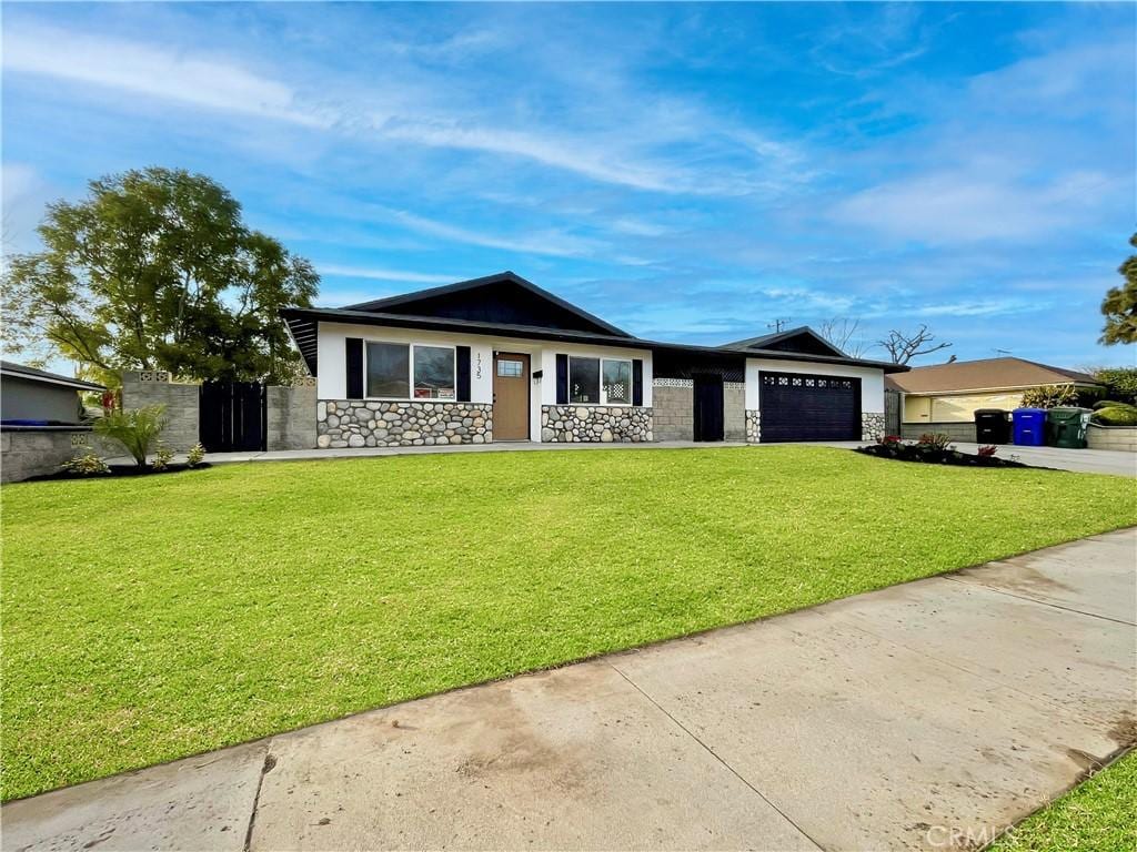 ranch-style home with a garage and a front lawn