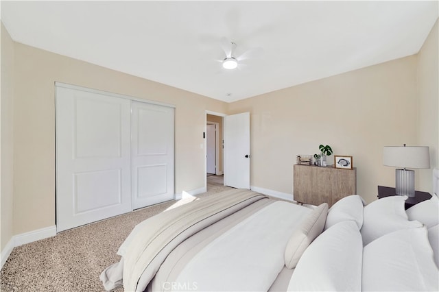 bedroom featuring baseboards, a closet, light carpet, and a ceiling fan