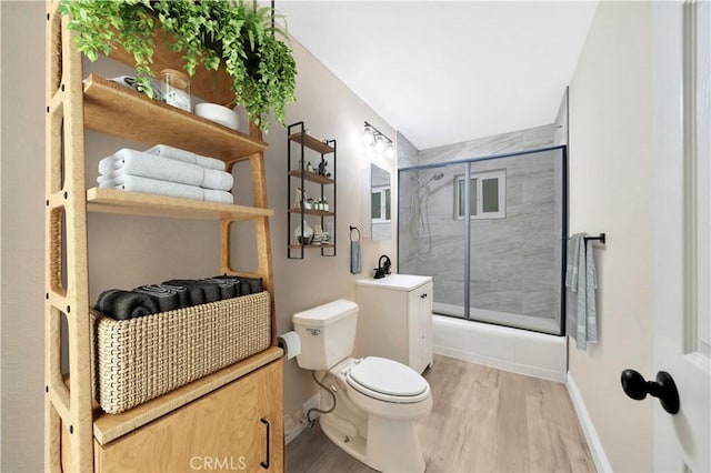 full bath featuring toilet, an enclosed shower, wood finished floors, baseboards, and vanity
