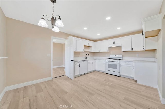 kitchen featuring white appliances, a sink, baseboards, light countertops, and recessed lighting