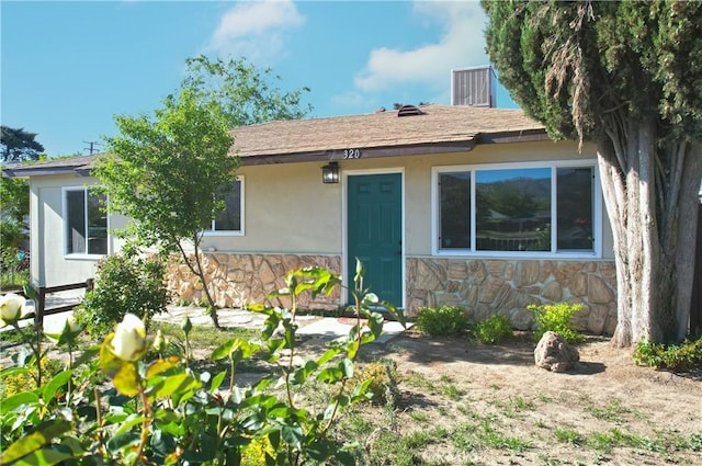 ranch-style house featuring stone siding and stucco siding
