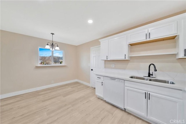 kitchen featuring dishwasher, a sink, light wood-style flooring, baseboards, and light countertops
