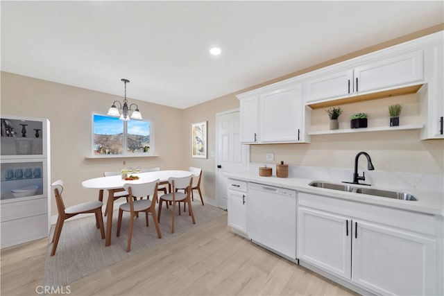 kitchen featuring white dishwasher, a sink, open shelves, light wood-style floors, and recessed lighting