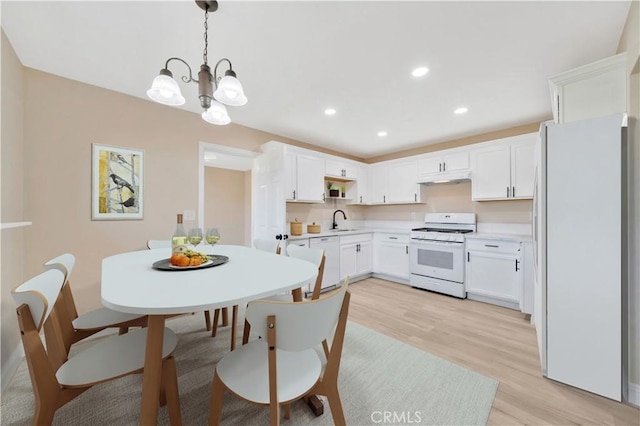 dining area with light wood finished floors, a chandelier, and recessed lighting