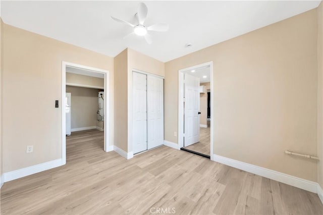 unfurnished bedroom with light wood finished floors, baseboards, and a closet