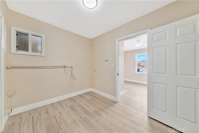 spare room featuring baseboards and light wood-style flooring