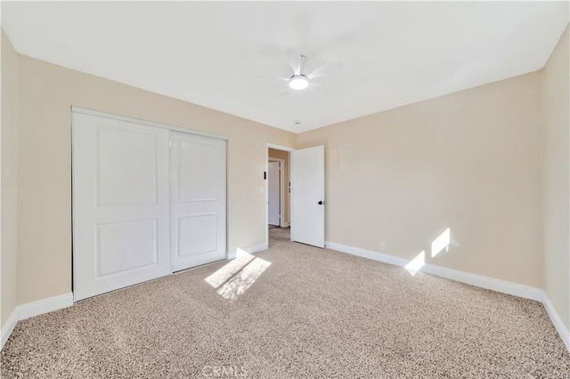 unfurnished bedroom featuring baseboards, light carpet, and a closet