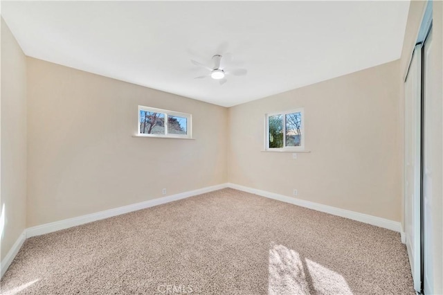 spare room featuring carpet, baseboards, and ceiling fan