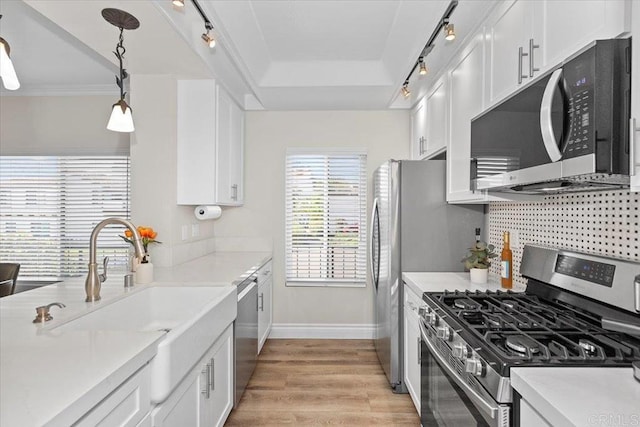 kitchen with pendant lighting, appliances with stainless steel finishes, and white cabinets