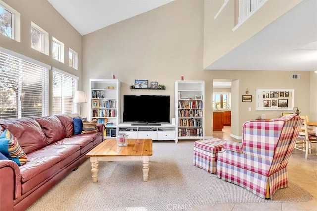 tiled living room featuring high vaulted ceiling