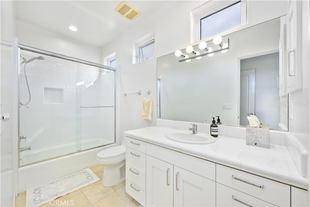 full bathroom featuring toilet, tile patterned floors, vanity, and bath / shower combo with glass door