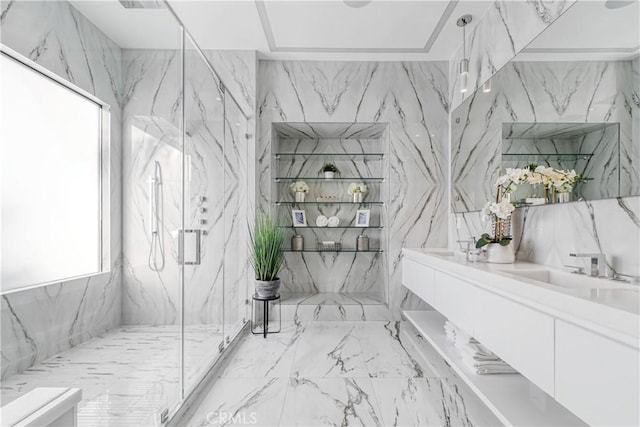 full bath with stone wall, a marble finish shower, double vanity, a sink, and tile walls