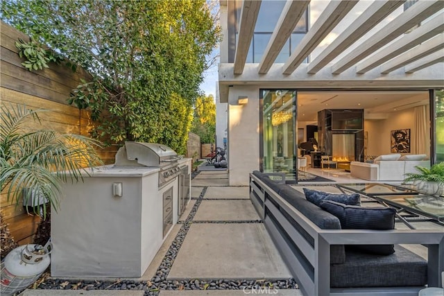 view of patio / terrace with grilling area, a pergola, exterior kitchen, and an outdoor hangout area