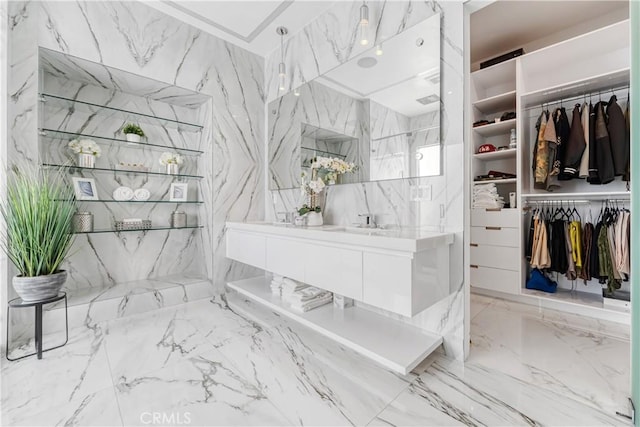 full bath with a walk in closet and stone wall