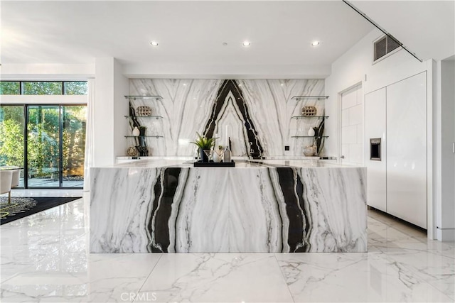 bar with stone wall, recessed lighting, and marble finish floor