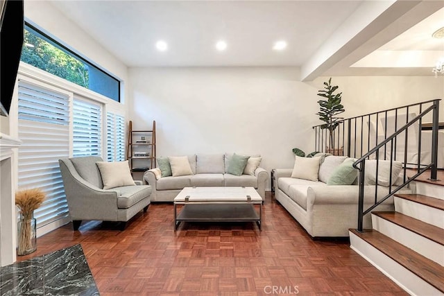 living room featuring dark parquet floors and a notable chandelier