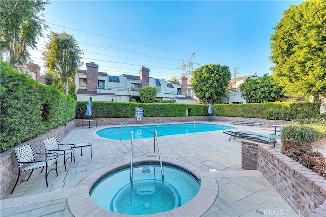 view of swimming pool featuring a patio and a community hot tub